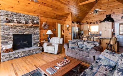 a living room with a stone fireplace in a cabin at Quiet Haven Mountain Top Cabin - 3 Bedroom Cabin with Breathtaking Views in Topton