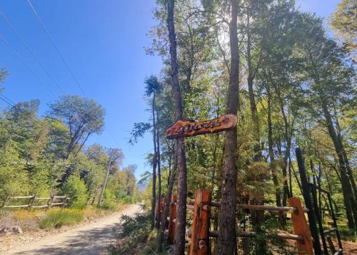 a sign in the woods next to a dirt road at Casa Ayllantú in Las Trancas