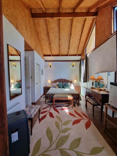 a bedroom with a bed and a bathroom with a sink at Casa Ayllantú in Las Trancas