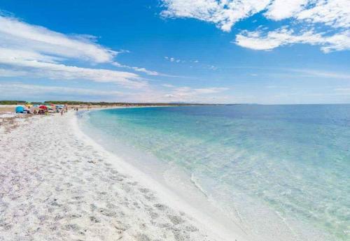 uma praia com areia branca e água azul em casa vacanza Il Delfino em Torre Grande