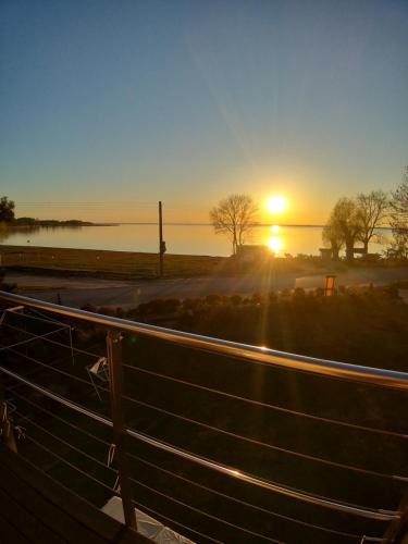 a sunset over a fence with the sun in the background at Nowe Guty Fun in Nowe Guty
