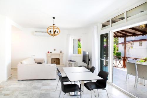 a white living room with a table and chairs at Luxury Villa in Türkbükü Bodrum Turkey close to Maca Kızı in Bodrum City