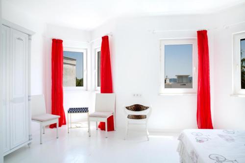 a bedroom with red curtains and a table and chairs at Luxury Villa in Türkbükü Bodrum Turkey close to Maca Kızı in Bodrum City