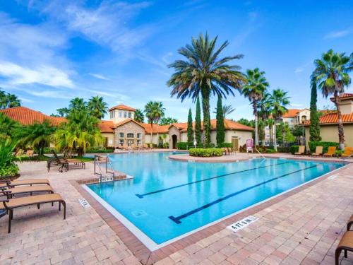 a swimming pool at a resort with palm trees at Florida Vacation Condo - No Resort Fees in Kissimmee