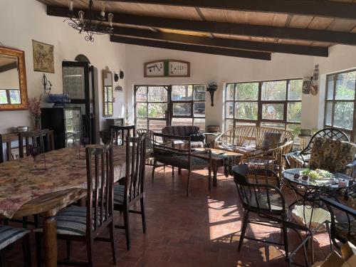 a dining room with tables and chairs and windows at Cabaña La Rinconada Cayara in Potosí