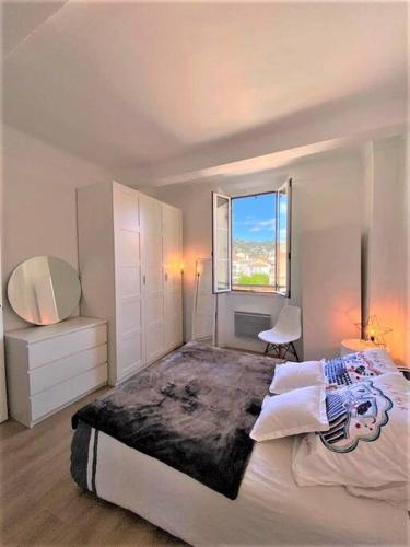 une chambre avec un grand lit avec une fenêtre dans l'établissement “ BonJour” Au cœur et au calme, à Cannes