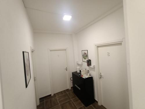 Casa Castelli في مسينة: غرفة ذات بابين بيض وخزانة سوداء