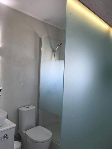a white bathroom with a toilet and a shower at Costa Ilios 3 Bedroom Flat in Ornos