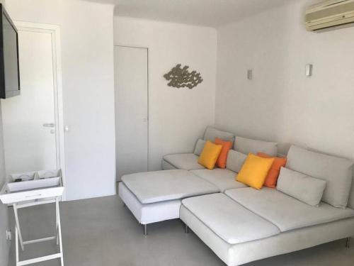un soggiorno con un divano bianco con cuscini colorati di Costa Ilios 3 Bedroom Flat a Ornos