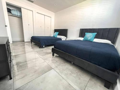 a bedroom with two beds with blue pillows at Luxurious & Modern Open Floor Plan Heated Pool Villa in Hollywood