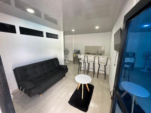 a living room with a black couch and a table at Apartamento independiente en casa in Girardot
