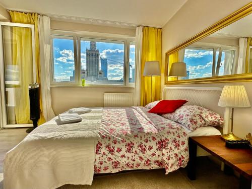 a bedroom with a bed with red pillows and a window at Super GOLD Centrum 2x Metro WiFi 600 Mb/s Netflix HBO AppleTV in Warsaw