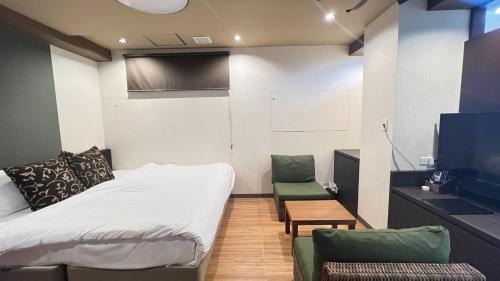 Habitación con 1 cama, 2 sillas y TV. en Shiki Building 5th Floor 6th Floor - Vacation STAY 62606v, en Naha