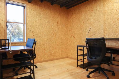ein leeres Zimmer mit zwei Schreibtischen und einem Stuhl in der Unterkunft Guesthouse Mow-Mow - Vacation STAY 88345v in Osaki