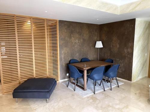 une salle à manger avec une table et des chaises bleues dans l'établissement Tour Végétale CFC Anfa Luxury, à Casablanca