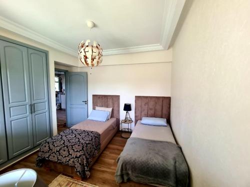 - une chambre avec 2 lits et un lustre dans l'établissement Chill and vibe house, à Sidi el Haj Bou Derbala