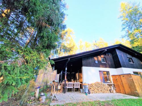 a barn with a table and chairs in front of it at Bungalow direkt am See, mit eigenem Boot in Roding