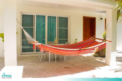 eine Hängematte auf einer Veranda eines Hauses in der Unterkunft Private Pool, With Access to Beach Club, VSandra, 2BR in Punta Cana