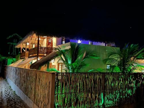 a house with a fence in front of it at night at Pousada Lanea Experience in Atins