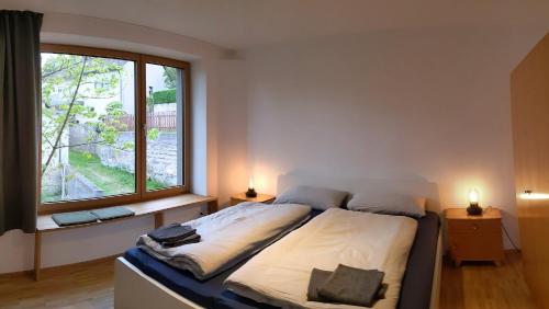 a bedroom with a bed and a large window at Kubus 28A in Gräfenberg