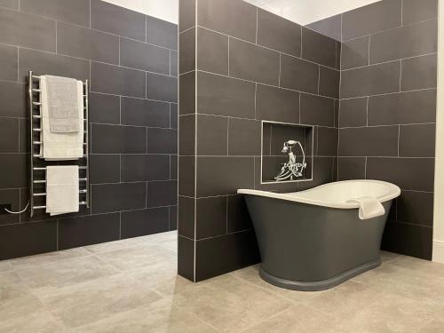 a bathroom with a bath tub and a toilet at The Viewmount Luxury Boutique in Kingussie