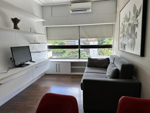 a living room with a couch and a tv at Ondina Apart Hotel Residences in Salvador