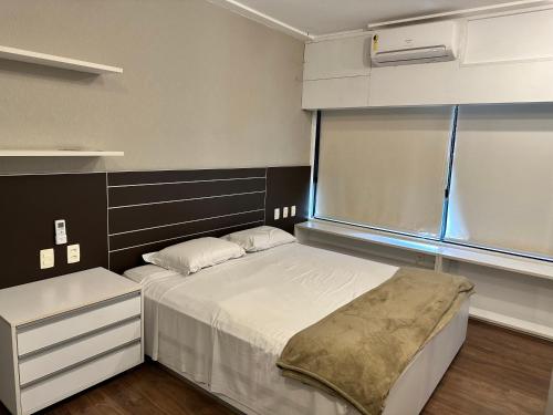 a small bedroom with a bed and a window at Ondina Apart Hotel Residences in Salvador