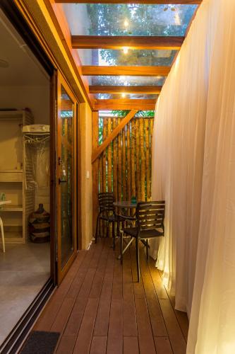 a screened in porch with a table and chairs at Casa d'Aroeira Residencial Boutique - Centro de Juqueí - 2 quadras do mar - Serviço de Praia - Roupa de Cama 600 fios algodão Egípcio - Toalhas Banho e Praia - Tudo Novo - Estacionamento Interno - Cozinha - Consulte unidades com Ofurô Hidro e Cromoterapia in Juquei
