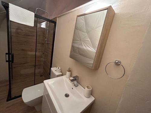 y baño con lavabo, aseo y espejo. en Luvinn Kayaköy, en Kayakoy