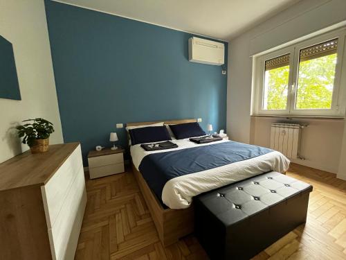 um quarto com uma cama e uma parede azul em The Bright Place: wide and modern condo apartment in Milan em Milão