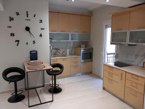 a kitchen with a table and a clock on the wall at Agapi’s apartment in Thessaloniki