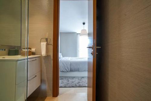 1 dormitorio con 1 cama y puerta al baño en Tour Végétale Luxury Anfa CFC Dalia, en Casablanca