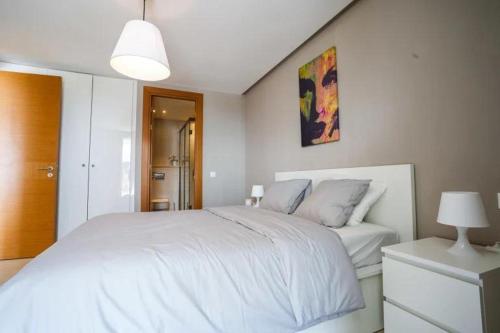 Un dormitorio con una gran cama blanca y una lámpara en Tour Végétale Luxury Anfa CFC Dalia, en Casablanca