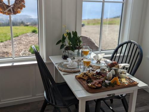 a table with a plate of food and drinks on it at Autumn Lane, modern Farmhouse Style B&B with Stunning Lakeviews in West Kelowna