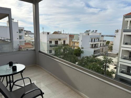 a balcony with a table and a view of a city at Aphrodite Holiday Home in Rethymno