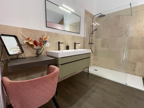 a bathroom with a sink and a pink chair at Suite intimiste insolite et luxueuse avec Spa Privatif- jacuzzi, vue de rêve in Cintegabelle