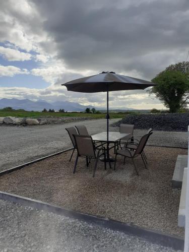 a table and chairs with an umbrella on the side of the road at Stable Hill House in Killarney