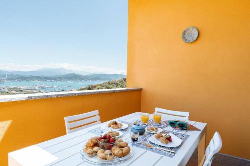 een tafel met borden met eten en drinken erop bij Piccapiana Sea View Attic Flat in La Spezia