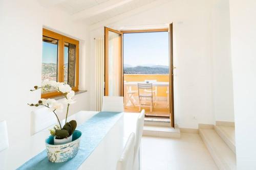 een witte kamer met een tafel met een vaas erop bij Piccapiana Sea View Attic Flat in La Spezia