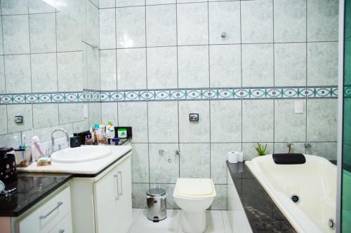 a bathroom with a sink and a toilet and a tub at Casa de campo Morada da Onça c WiFi - Capitólio - MG in Capitólio