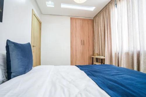 a bedroom with a blue and white bed and a window at Modern Unit Well located in Casablanca