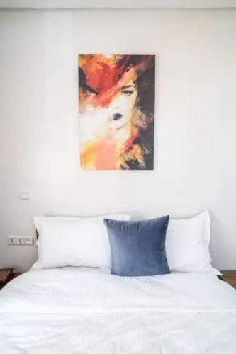 a bedroom with a white bed with a painting on the wall at Modern Unit Well located in Casablanca