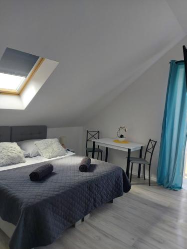 a bedroom with a bed and a table at Pokoje i apartamenty MatDar in Mikołajki