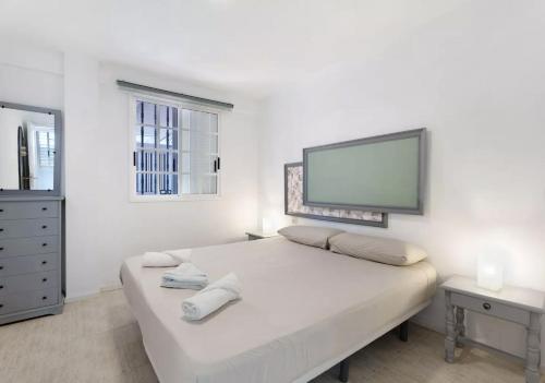 1 dormitorio blanco con 1 cama y TV de pantalla plana en Apartamento El Carmen 3 Lara, en Santa Cruz de Tenerife