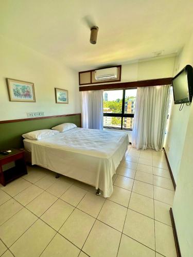 a bedroom with a bed and a tv in it at Ondina Apart Hotel Residences in Salvador