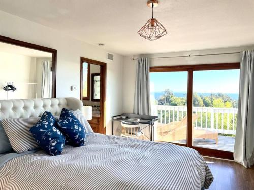 1 dormitorio con 1 cama con almohadas azules y balcón en Malibu Seaside Bliss with Hot Tub and Beach & Hike nearby en Malibu