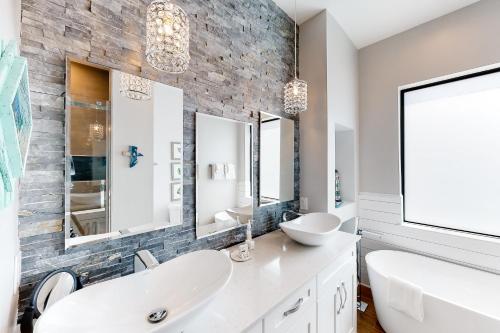 a bathroom with a white sink and a stone wall at Pure Aquamarine in Key Largo