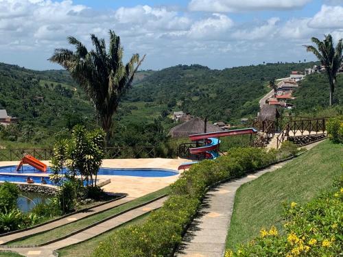 uma piscina num resort com uma palmeira em Cond. Sonhos da Serra em Bananeiras