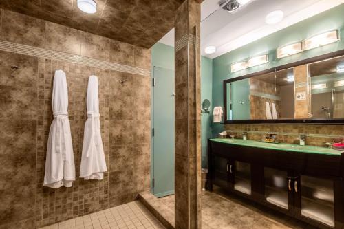 Best Western Plus NorWester Hotel & Conference Centre في ثاندر باي: حمام مع حوض ومرآة