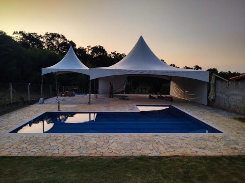 a white tent with a pool in a yard at Chácara Buscapé in Mogi das Cruzes